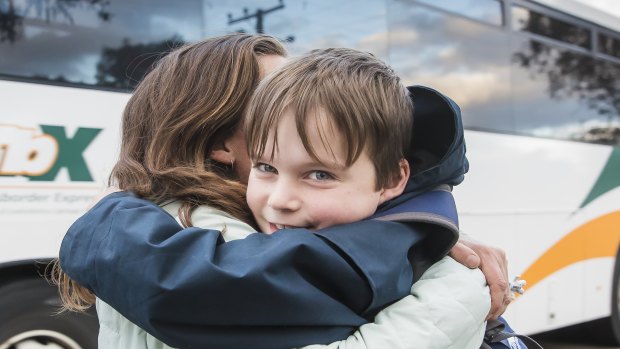 Timothy Pengilly hugs his mother Roz after getting off the school bus near his Murrumbateman home. He makes the long commute to Canberra every school day. 