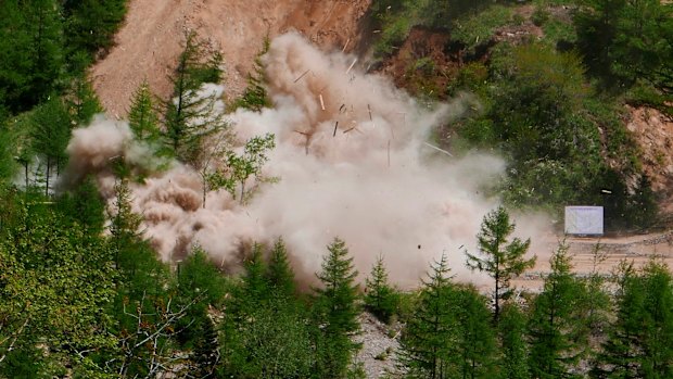 Smoke and debris rise in the air as an observation post next to the entrance of the north tunnel at North Korea's nuclear test site is blown up.