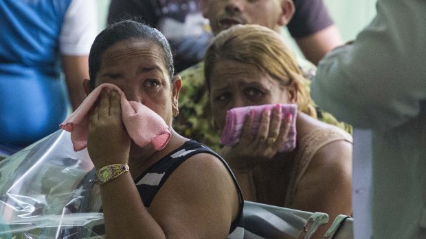 Grieving relatives of passengers who perished in Cuba's worst aviation disaster wait for the identification of the bodies at the morgue in Havana.