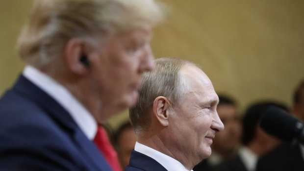 Russian President Vladimir Putin smiles during a press conference with US President Donald Trump 