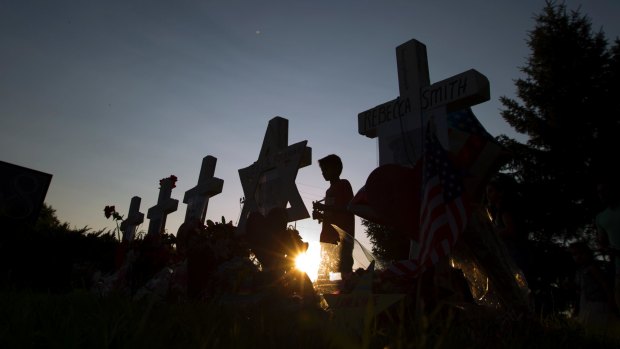 A child looks at the five crosses representing the journalist killed, at a makeshift memorial outside the office building housing The Capital Gazette in Annapolis.