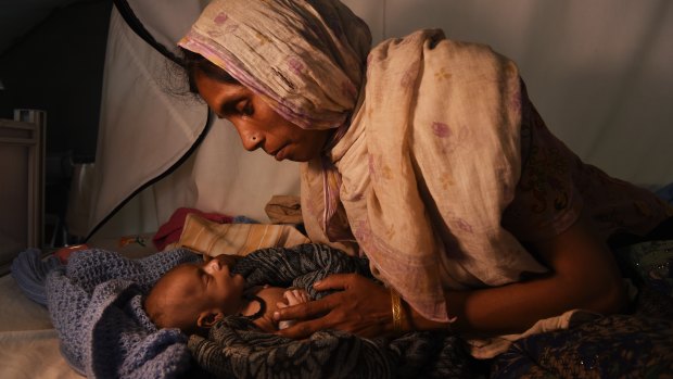 Refugee Laila Begum holds her son Mohammed Ifran’s hand as he receives treatment at the Red Cross Field Hospital in Kutupalong refugee camp, Cox’s Bazar, Bangladesh, in November. 