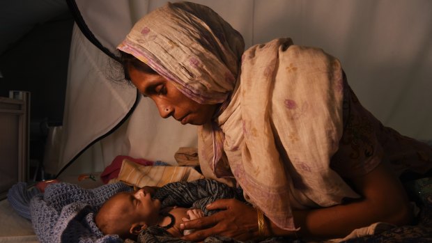 Refugee Laila Begum holds her son Mohammed Ifran’s hand as he receives treatment at the Red Cross Field Hospital in Kutupalong refugee camp, Cox’s Bazar, Bangladesh, in November. 