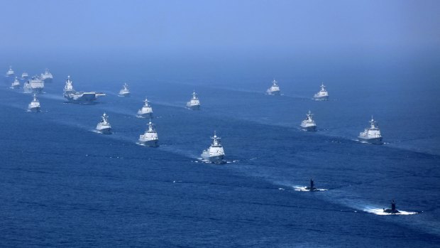 Chinas's Liaoning aircraft carrier is accompanied by navy frigates and submarines conducting an exercises in the South China Sea. 