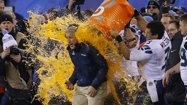 Getting a drenching: Seahawks quarterback Russell Wilson dumps Gatorade on head coach Pete Carroll