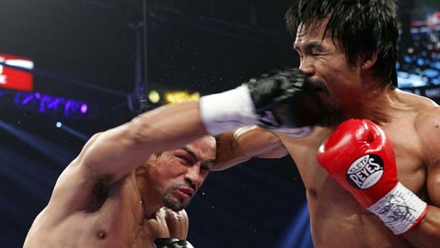 Toe-to-toe ... Juan Manuel Marquez, left, punches Manny Pacquiao.
