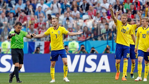 Sweden's Sebastian Larsson, second right, asks  referee Joel Aguilar to review a decision.