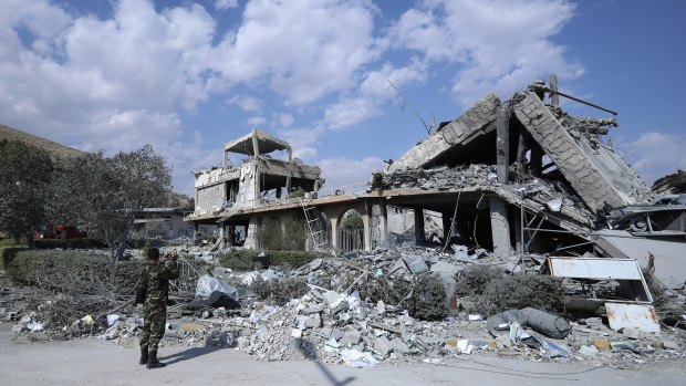 A Syrian soldier films the damage of the Syrian Scientific Research Center.