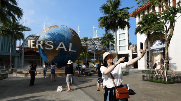 Tourists take selfies outside the Universal Studios theme park in Sentosa.