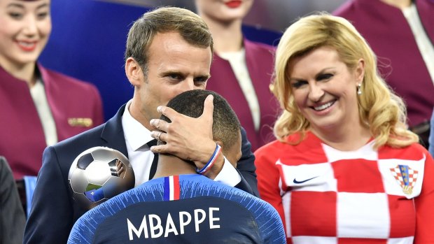 French president Emmanuel Macron kisses Kylian Mbappe.