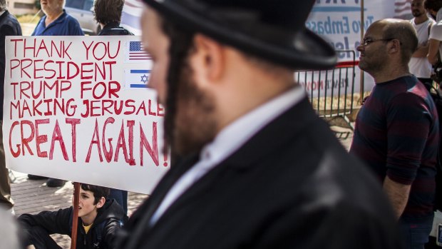 Ultra orthodox Jews stand by supporters of Donald Trump outside the new American embassy in Jerusalem on Monday.