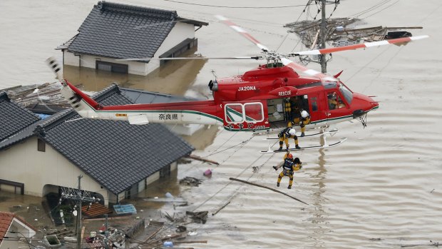 A resident is rescued in a flooded area in Kurashiki, Okayama prefecture, following heavy rain. 
