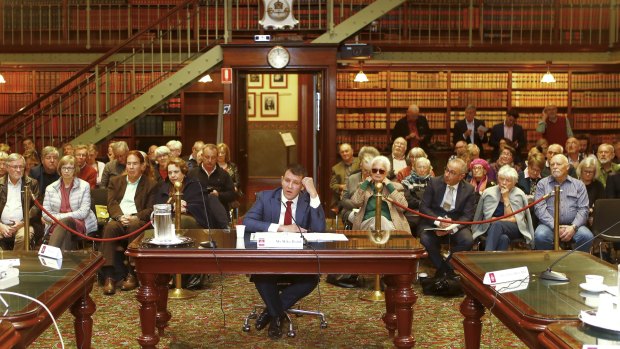 Mike Baird gives evidence before a packed public gallery. 