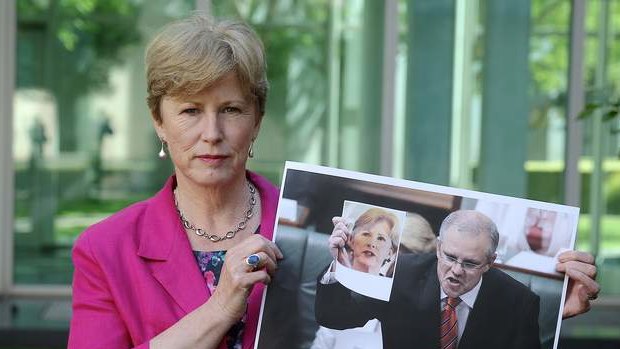 Greens leader Senator Christine Milne holds up the photograph of Immigration Minister Scott Morrison holding up her photograph during Question Time on Tuesday. Photo: Alex Ellinghausen