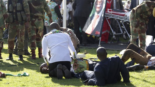 Injured people are attended to as they lay on the ground following the explosion in Bulawayo.