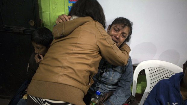 Ruth Rivas, who has two missing children, is consoled by a neighbor in a shelter near Guatemala's  Volcan de Fuego.