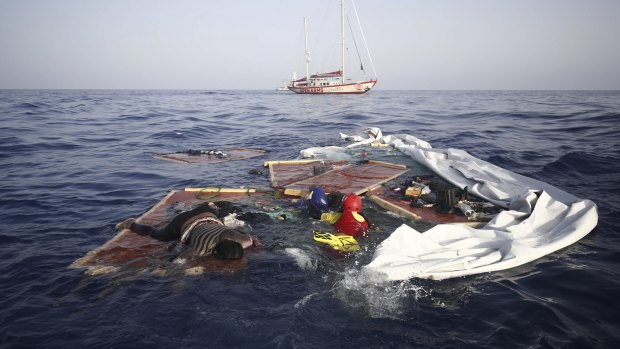 Rescue workers from the Proactiva Open Arms Spanish NGO retrieve the bodies of an adult and a child amid the drifting remains of a destroyed migrant boat off the Libyan coast.