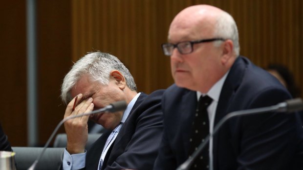 Attorney-General Senator George Brandis and department Secretary Chris Moraitis at a Senate committee hearing in Canberra on Tuesday.