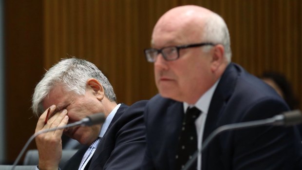 Attorney-General Senator George Brandis and department Secretary Chris Moraitis at a Senate committee hearing in Canberra on Tuesday.