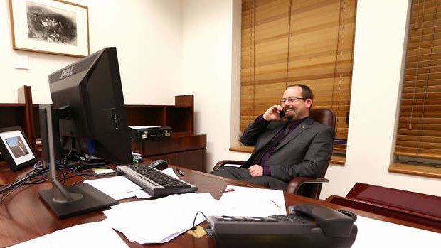 Senator Ricky Muir gives his wife a ring after the schoolkids bonus was saved during the repeal of the mining tax, in his office at Parliament House. Photo: Alex Ellinghausen