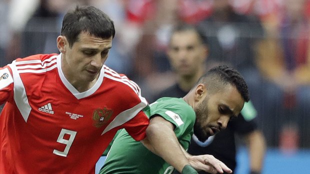 Russia's Alan Dzagoev, left, and Saudi Arabia's Mohammed Alburayk challenge for the ball during the group A match between Russia and Saudi Arabia which opened the 2018 soccer World Cup.

