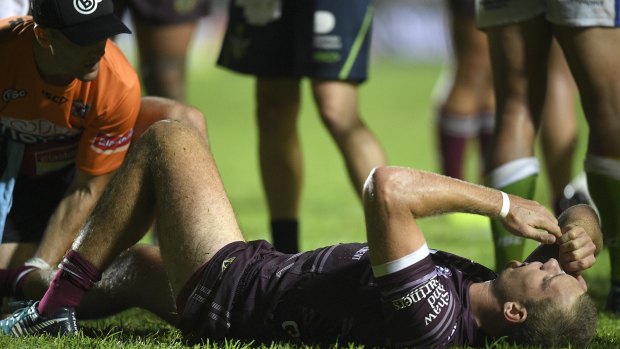 Grounded: Tom Trbojevic of the Sea Eagles receives attention from a trainer .