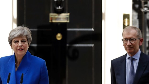 British Prime Minister Theresa May addresses the press in Downing street as her husband Philip looks on.