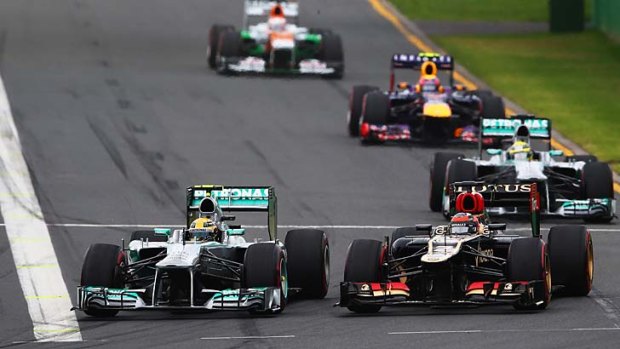 Lewis Hamilton of Great Britain and Mercedes GP and Kimi Raikkonen of Finland and Lotus drive side by side into turn one.