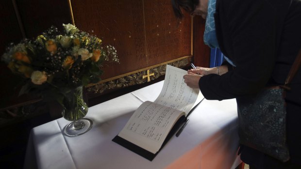 Members of the public sign a book of condolence at Gonville and Caius College.