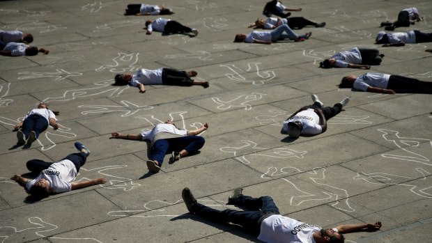Activists lay on the ground to mark World Refugee Day during a protest in Madrid.