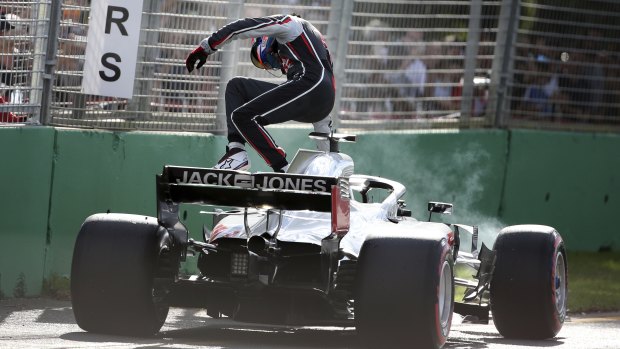 Haas driver Romain Grosjean of France leaps from his car after stopping with engine failure.