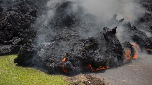 Lava creeps across the road in the Leilani Estates in Pahoa, Hawaii. 