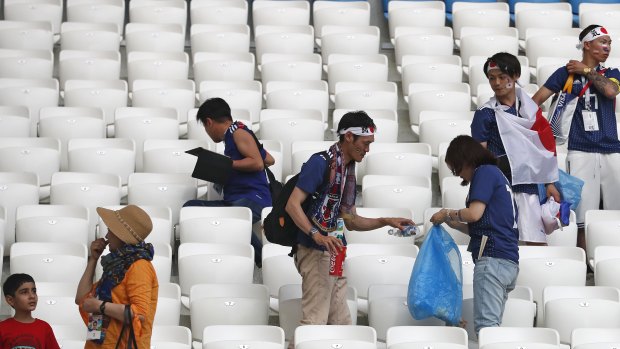 Fair play in the stands: Japanese fans clean up after themselves post-game.