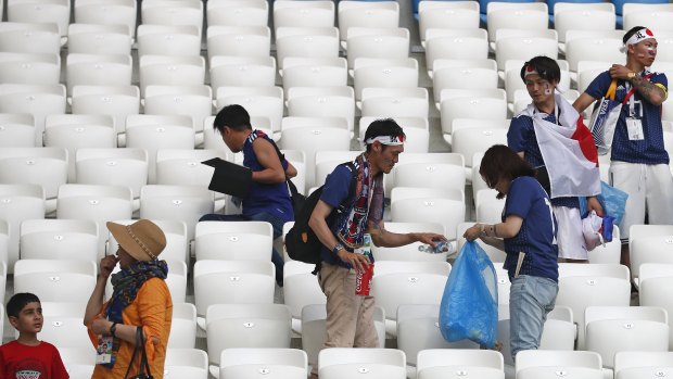 Fair play in the stands: Japanese fans clean up after themselves post-game.