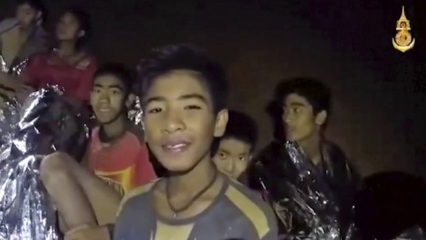 Thai boys smile as a Thai Navy SEAL medic helps the injured in the cave earlier in the week.