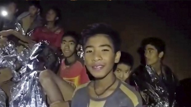 Thai boys smile as a Thai Navy SEAL medic helps the injured in the cave earlier in the week.