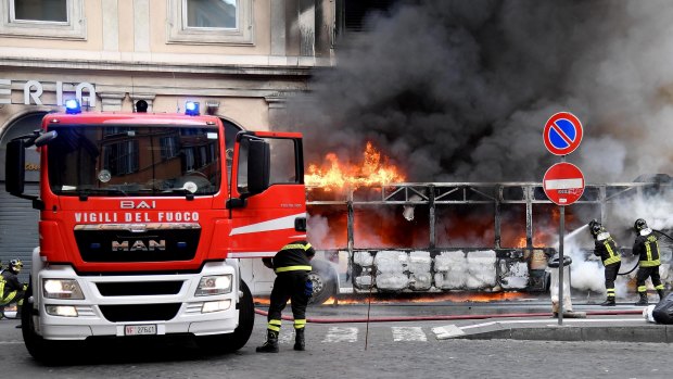 Firefighters hose down a fire on a bus in central Rome.