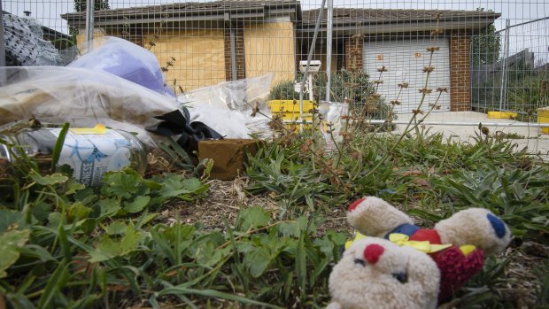 Old flowers and toys outside the scene of a fatal fire on Peter Coppin Street in Bonner, which will soon be demolished.
