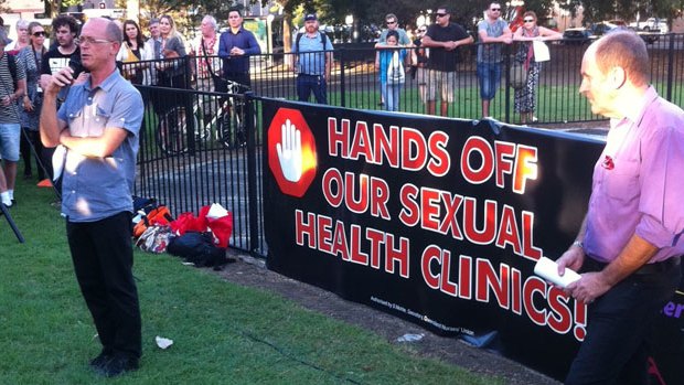 A patient of Biala House who has been using the services provided for over 25 years addresses a crowd protesting job cuts at the sexual health clinic in Brisbane this afternoon.