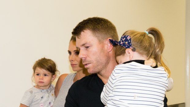Rough few days: David Warner arrives in Sydney with his family on Thursday night.