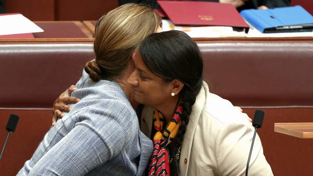 Senator Kate Lundy embraces Senator Nova Peris after she delivered a statement to the Senate on Thursday.