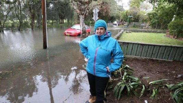 Claire Smith beside the flooded Cooks Rover at Marrickville.