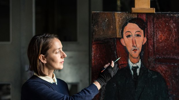 Raye Collins with the painting she brought back to life – Amedeo Modigliani’s Portrait of the painter Manuel Humbert.
