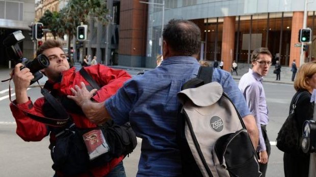 Former AWU official Bruce Wilson attacks a photographer outside the Royal Commission in Sydney.