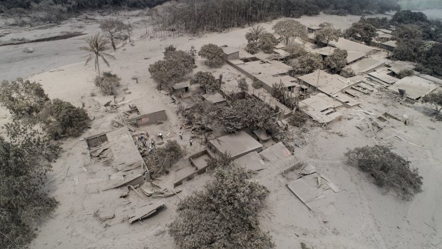 Rescue workers search in El Rodeo, one of the villages destroyed by the Volcan de Fuego in Guatemala.