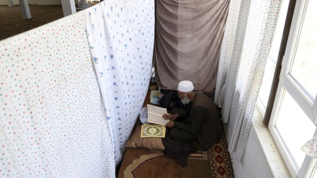 An Afghan Muslim man reads versus of the Quran in a mosque during Itikaf, the last ten days of the Islamic fasting month of Ramadan, in Kabul, Afghanistan.