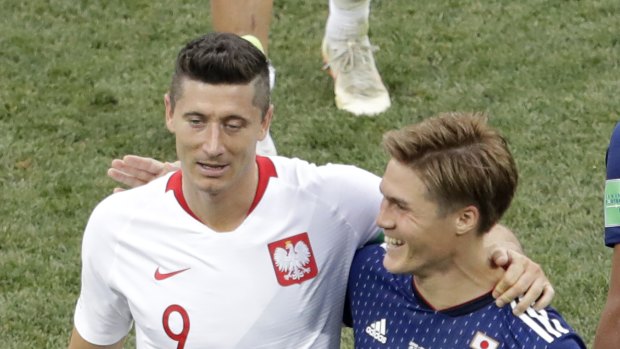 Everyone's a winner: Poland's Robert Lewandowski, left, and Japan's Gotoku Sakai embrace each other at the end of the match.