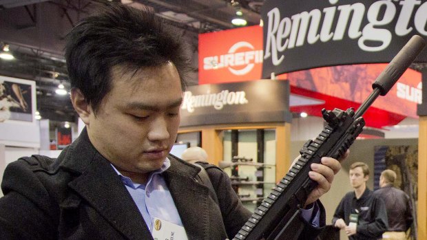 Kevin Kao, of Irvine, California, examines a military grade Remington Adaptive Combat Rifle at the 35th annual SHOT Show in Las Vegas. 