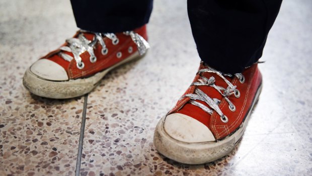 An immigrant fleeing Central America uses what appears to be plastic foil for shoelaces after the cloth ones were confiscated by the US Border Patrol. 