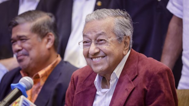 Mahathir Mohamad, centre, celebrates at a hotel in Kuala Lumpur, Malaysia.